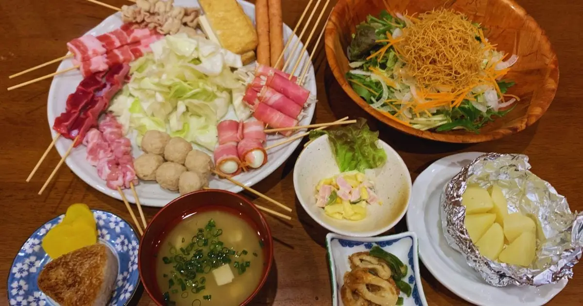 Assorted yakitori skewers, salad, and grilled rice balls