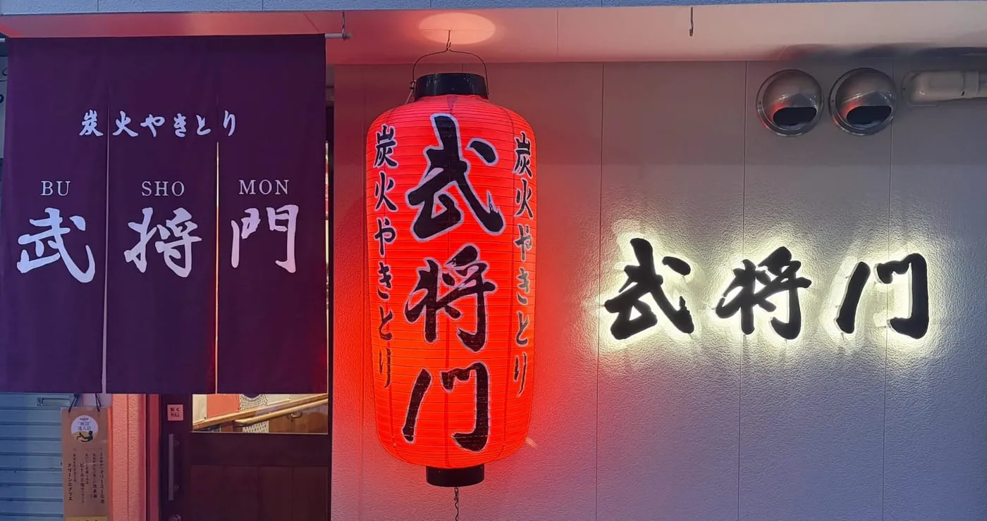 夜の武将門の店構え。赤提灯と暖簾